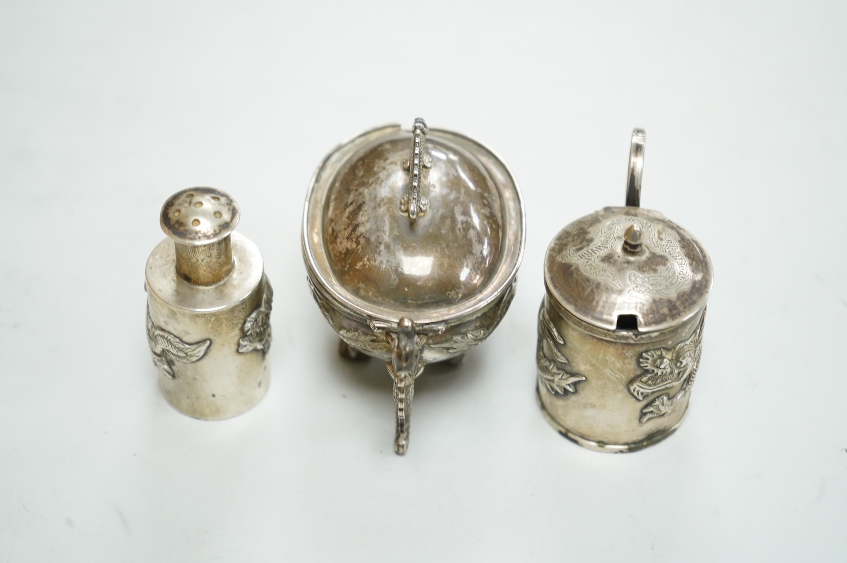 Three early 20th century Chinese export white metal condiments including a drum mustard pot and pepperette by Wang Hing, Hong Kong, pepperette 63mm.